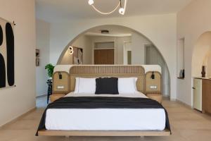 a bedroom with a large bed with an arch above it at Apanemo Private Suites in Akrotiri +46 photos