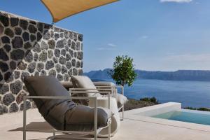 a group of chairs sitting next to a swimming pool at Apanemo Private Suites in Akrotiri