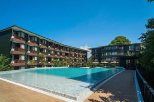 a swimming pool in front of a building at Wyndham Garden Samui Wing in Chaweng