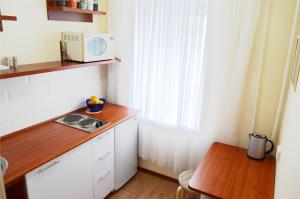 a small kitchen with a table and a microwave at "GOOD NIGHT" on Pirogova 7 in Tomsk