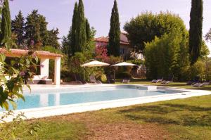 a swimming pool in a yard with chairs and umbrellas at Lei Meissoun in Mallemort