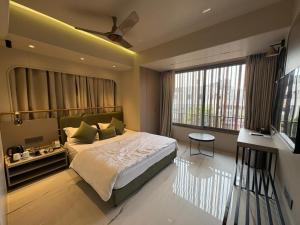 a bedroom with a bed and a large window at Dormstel - Unit of AHM Hotels & Resorts Pvt Ltd in Vadodara