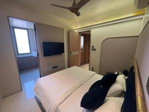 a bedroom with two beds and a flat screen tv at Dormstel - Unit of AHM Hotels & Resorts Pvt Ltd in Vadodara