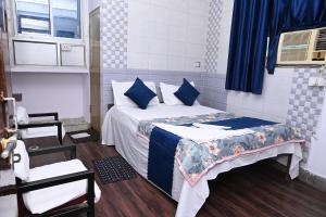 a bedroom with a bed with blue and white pillows at Hotel Bluebell Inn in Lucknow