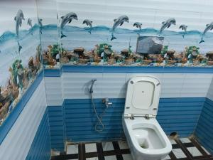a bathroom with a toilet with a painting on the wall at Diamond Blue Residency in Durgāpur