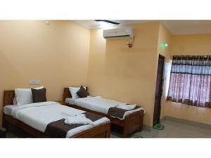 a room with two beds and a window at Diamond Blue Residency in Durgāpur +8 photos