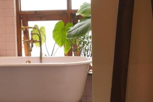 a bathroom with a tub and a plant in a window at Dreamershomecoffee in Xuan An +81 photos