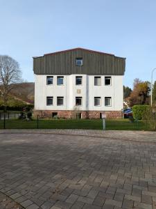 a large white building with a black roof at Ferienwohnung Schöntalweiher in Ludwigswinkel