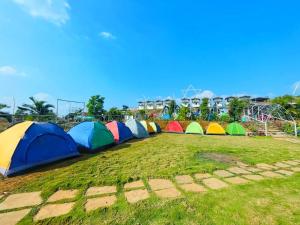 a row of colorful tents in a field at Camping At Pawana in Malavli