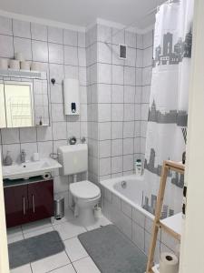 a bathroom with a toilet and a sink and a tub at Modern 2-Room Apartment with Free Parking and Balcony in Waldmohr +16 photos