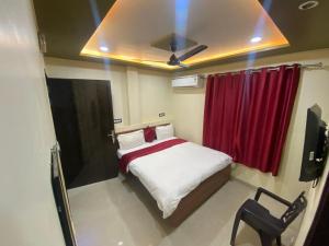 a small bedroom with a bed with a red curtain at Royal Paradise Guest House in Varanasi
