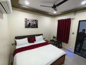 a bedroom with a bed and a red curtain at Royal Paradise Guest House in Varanasi