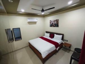 a bedroom with a bed and a tv in it at Royal Paradise Guest House in Varanasi +23 photos