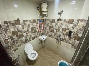 a bathroom with a toilet and a sink at Royal Paradise Guest House in Varanasi