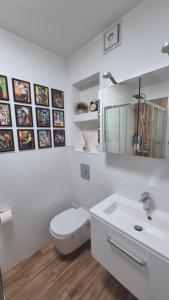 a white bathroom with a toilet and a sink at Apartment Ultra-Central, Parcare, AC, Jaluzele, WiFi in Baia Mare +11 photos