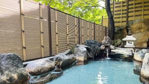 a swimming pool with a waterfall in a zoo at Kinugawa Royal Hotel in Nikko