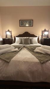 a bedroom with a large white bed with two lamps at Αρχοντικό Μελλιώ Άγιος Λαυρέντιος in Agios Lavrentios