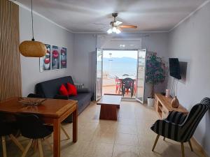 a living room with a couch and a table and a dining room at Frente Mar in L'Escala