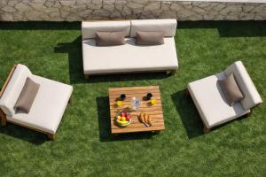 a living room with two chairs and a table with fruit at Holiday House Maze with jacuzzi in Novalja