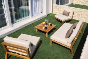 an outdoor patio with two chairs and a table at Holiday House Maze with jacuzzi in Novalja