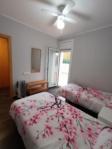 a bedroom with two beds and a ceiling fan at Frente Mar in L'Escala +55 photos