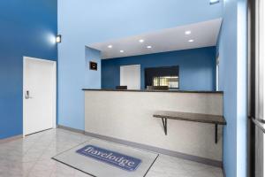 a lobby with a bench in a blue wall at Travelodge by Wyndham Banning Casino and Outlet Mall in Banning +32 photos