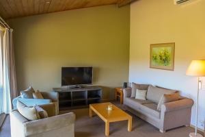 a living room with two couches and a flat screen tv at Gipsy Point Lakeside in Gipsy Point