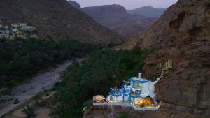 a building on the side of a mountain at Hawer Inn - wadi bani Khalid in Biḑ‘ah