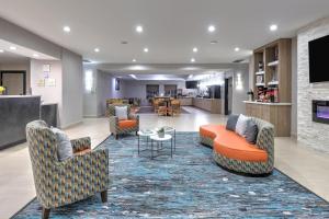a hotel lobby with couches and chairs and a table at La Quinta Inn and Suites by Wyndham Paris in Paris