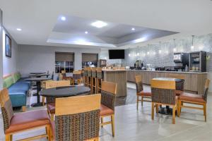 a restaurant with tables and chairs and a bar at La Quinta Inn and Suites by Wyndham Paris in Paris