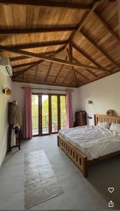 a bedroom with a large bed with a wooden ceiling at Ruvee Villa in Weligama