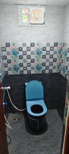 a bathroom with a blue toilet in a room at DD Gardens in Rāmeswaram