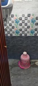 a pink cake sitting on the floor in a bathroom at DD Gardens in Rāmeswaram