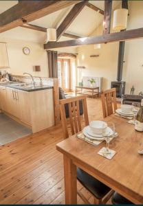 a kitchen and dining room with a wooden table and chairs at Old Well Cottage Barn Conversion in Penrith