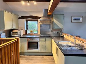 a large kitchen with stainless steel appliances and counters at Old Well Cottage Barn Conversion in Penrith +6 photos