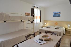 a room with two bunk beds and a table at Agriturismo Vistamare in Orosei