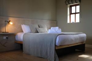 a bedroom with a large bed with white sheets and pillows at Storytellers Cottage in Doolin