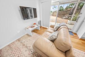 a living room with a couch and a television at Cromwell Lite in Cooma