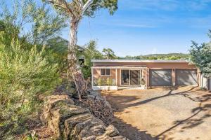 a contemporary home with a stone retaining wall at Cromwell Lite in Cooma