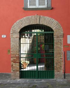 una puerta verde frente a un edificio rojo en B&B La Polinnia, en Bagnoregio