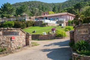 a house on a hill with a stone wall at Domaine de Sonia - Logements éco-insolites in Porto-Vecchio