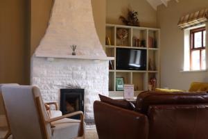 a living room with a fireplace and a couch at Storytellers Cottage in Doolin
