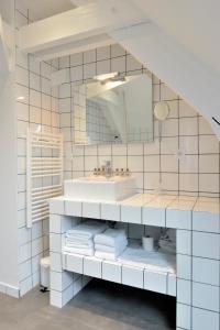 a white bathroom with a sink and a mirror at Hôtel Le Collonges TV connecté wifi Netflix in Brive-la-Gaillarde