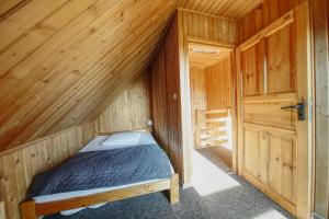 a bedroom with a bed in a wooden cabin at Domek u Małysza in Istebna