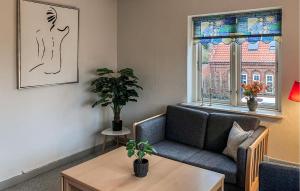 a living room with a couch and a table and a window at Amazing Apartment In Hundested With Wifi in Hundested
