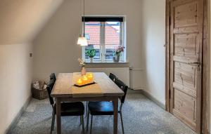 a dining room with a table with chairs and a window at Amazing Apartment In Hundested With Wifi in Hundested
