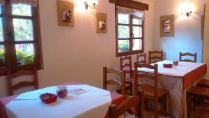 a restaurant with two tables and chairs and windows at Posada Casa Fidela in Lomeña