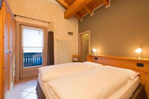 two beds in a room with a window at Al Chestelet in Livigno