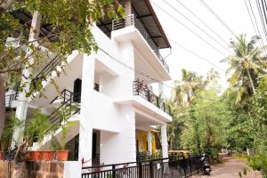 a white building with a black fence in front of it at Patnem Bliss in Canacona
