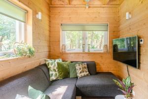 a living room with a couch and a flat screen tv at Chalet Citola in Nuenen
